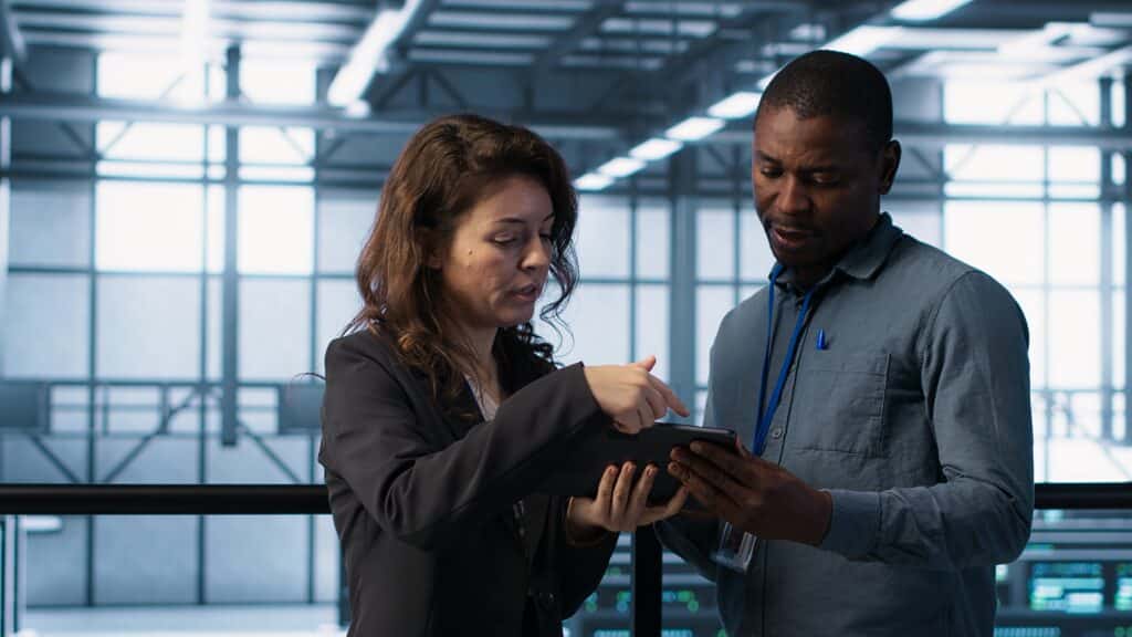 CRM ERP - Profissionais analisando informações em tablet em ambiente corporativo, representando colaboração, tecnologia e integração de processos.